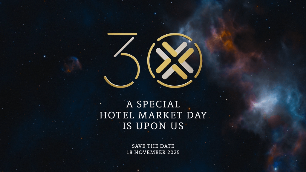 A person on stage presents a slide showing "Europe 55%" with a bar chart, in a dimly lit auditorium with an audience.